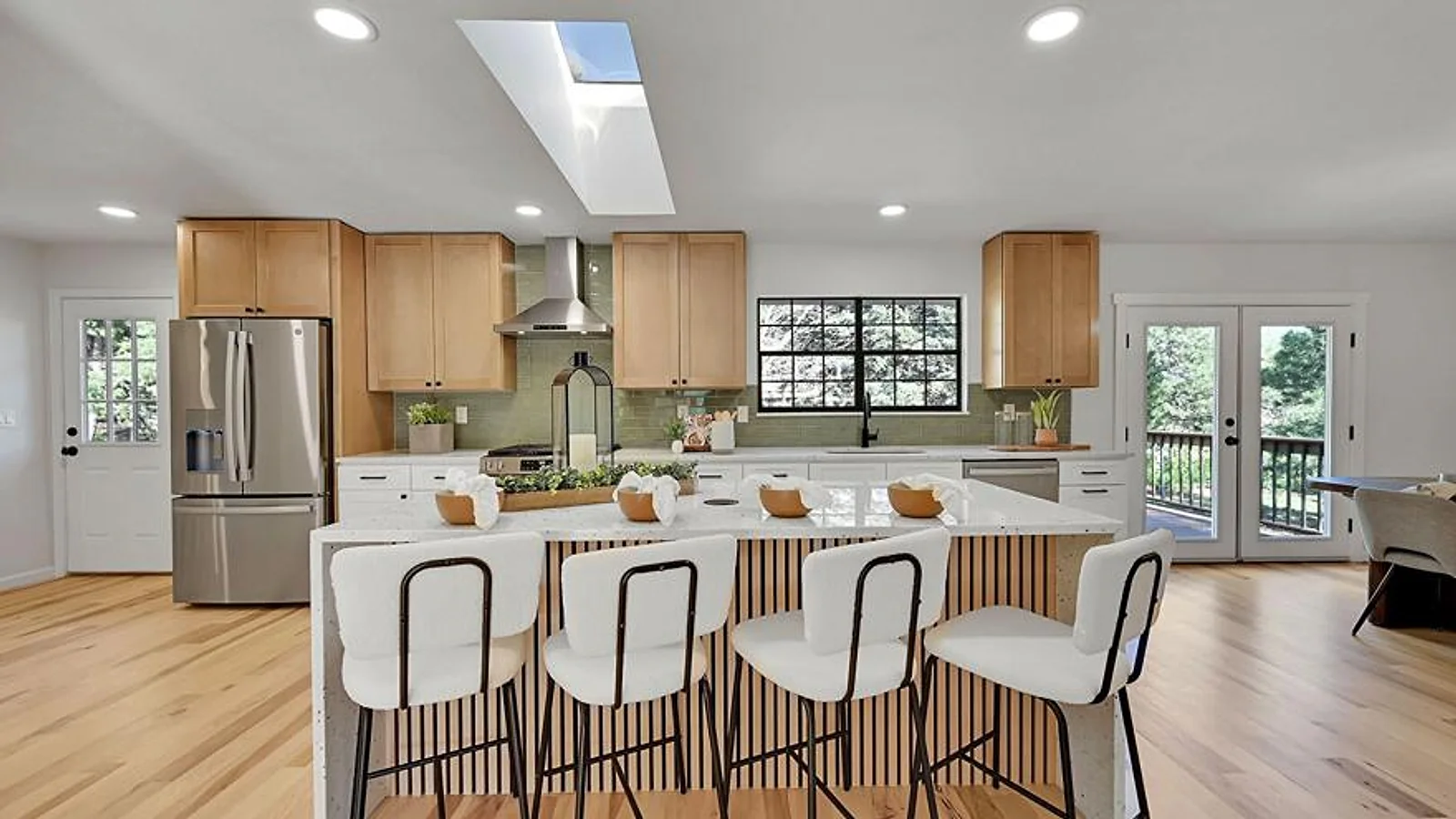 Custom maple and white shaker kitchen cabinets with a quartz waterfall island and sage tile backsplash in a Treasure Valley, Idaho home by Boise Cabinet Co